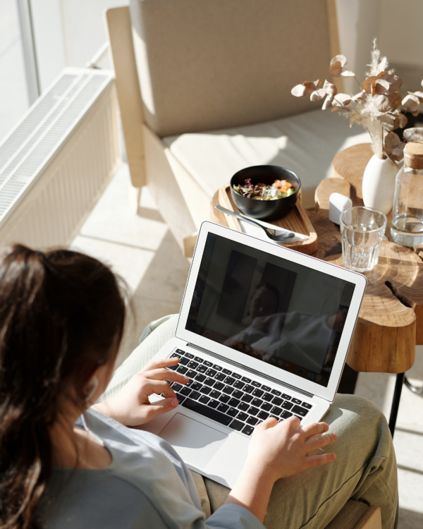 Person Sitting With Their Laptop On Their Lap, Working in the Sunshine